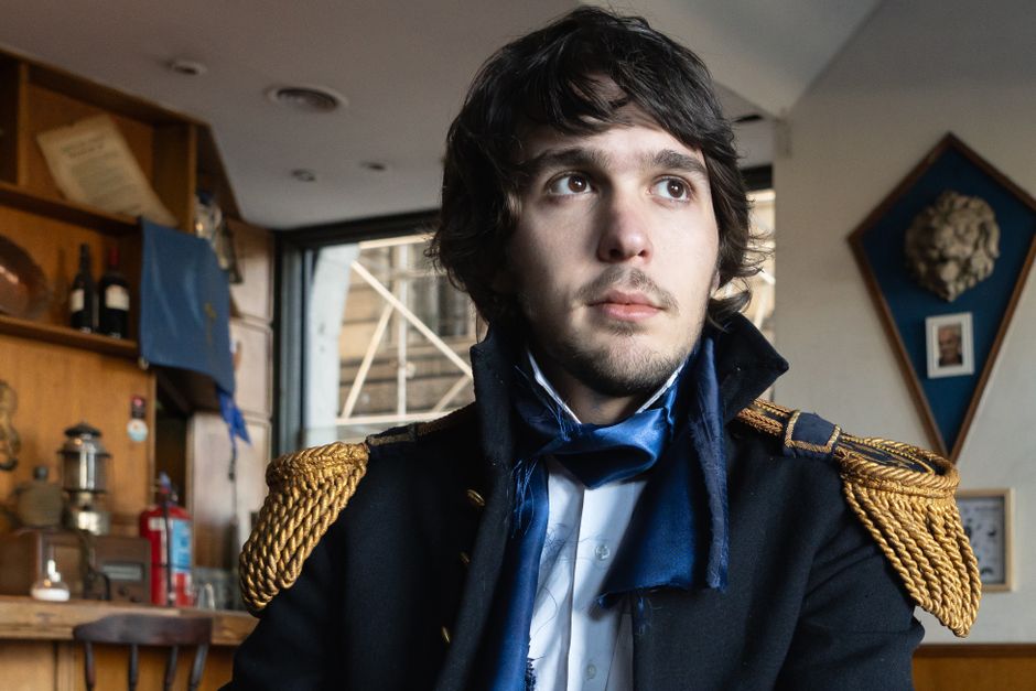 Portrait of a man in historic costume inside a Buenos Aires cafe, evoking a classic ambiance.
